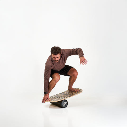 Man on the Indo balance board featuring the Rocker model and performance roller.