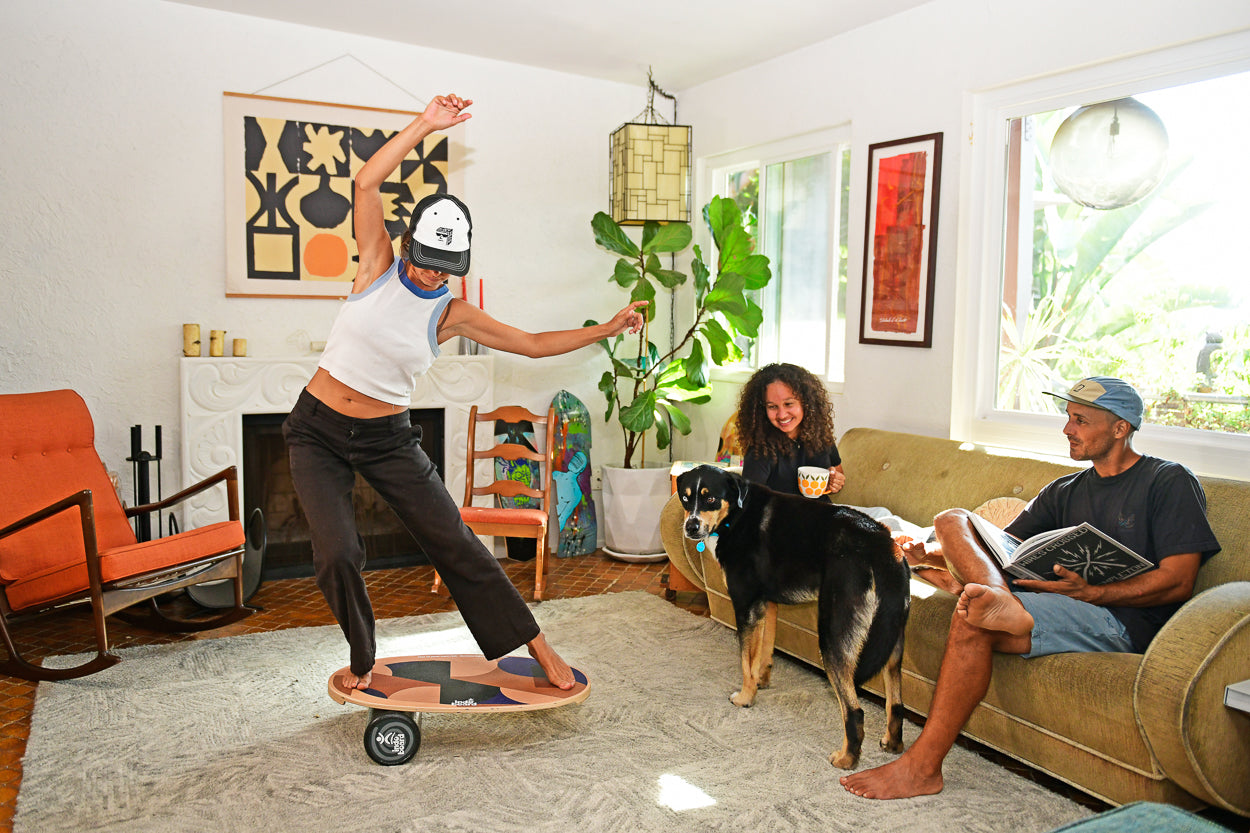 INDO BOARD Original - Roller Cushion - Ola Grande in use in a bright living room, showing balance training as others observe.